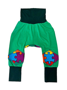 Green pants with colorful puzzle piece design on a white background
